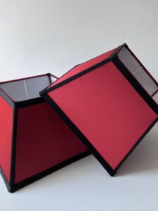 Abat-jour rouge soyeux bordé de gros grain noir. A VENDRE